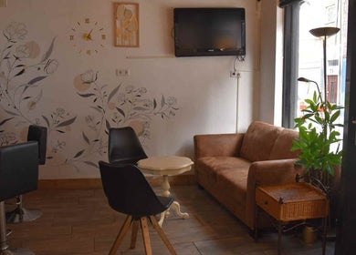 Chic seating area at Piercink Garden Tattoo & Piercing in Beverwijk, Noord-holland, NL. Cozy sofa and modern chairs.