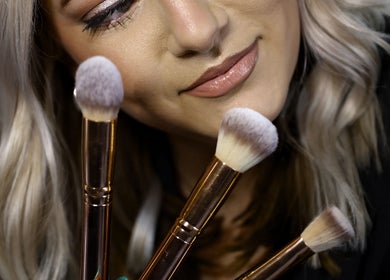 A stylist at Kylie’s Beauty Studio in Cape Town showcasing premium makeup brushes for flawless applications.