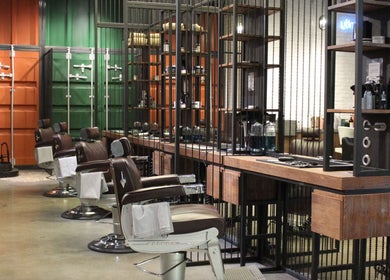 Modern barber chairs at Hair District Barbershop in Dubai, Dubai, AE, showcasing sleek interior design.