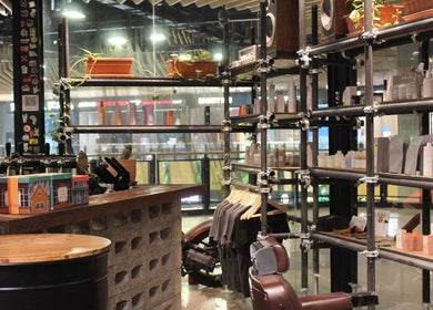 Hair District Barbershop's stylish interior featuring products and seating in Dubai, Dubai, AE.