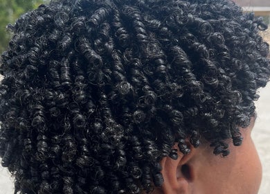 Close-up of styled curly hair at Melena Hair Studio, Willemstad, Curaçao, CW showcasing intricate curls.