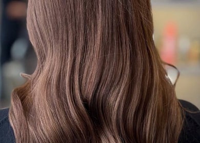 Glossy, wavy brown hair styled at Moeibrahem, Muscat, OM, showcasing salon expertise.