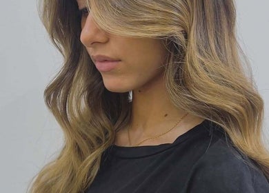 Elegant wavy hairstyle at Moeibrahem, Muscat, OM salon showcasing beautiful blonde highlights.