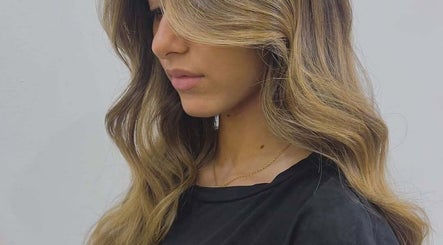 Elegant wavy hairstyle at Moeibrahem, Muscat, OM salon showcasing beautiful blonde highlights.