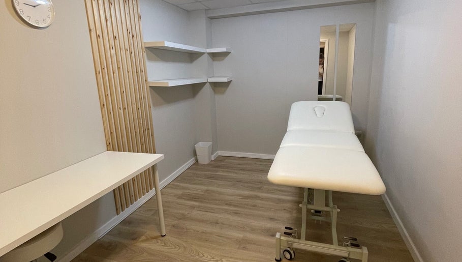 Minimalist therapy room at True Form Therapy Ltd in Three Legged Cross, England, GB with a massage table.