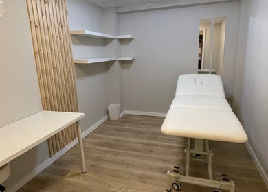 Minimalist therapy room at True Form Therapy Ltd in Three Legged Cross, England, GB with a massage table.