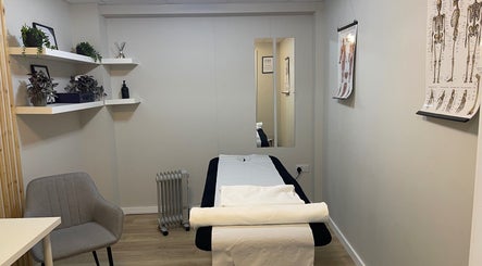 Tranquil therapy room at True Form Therapy Ltd, Three Legged Cross, England, GB, with a massage table and decor.