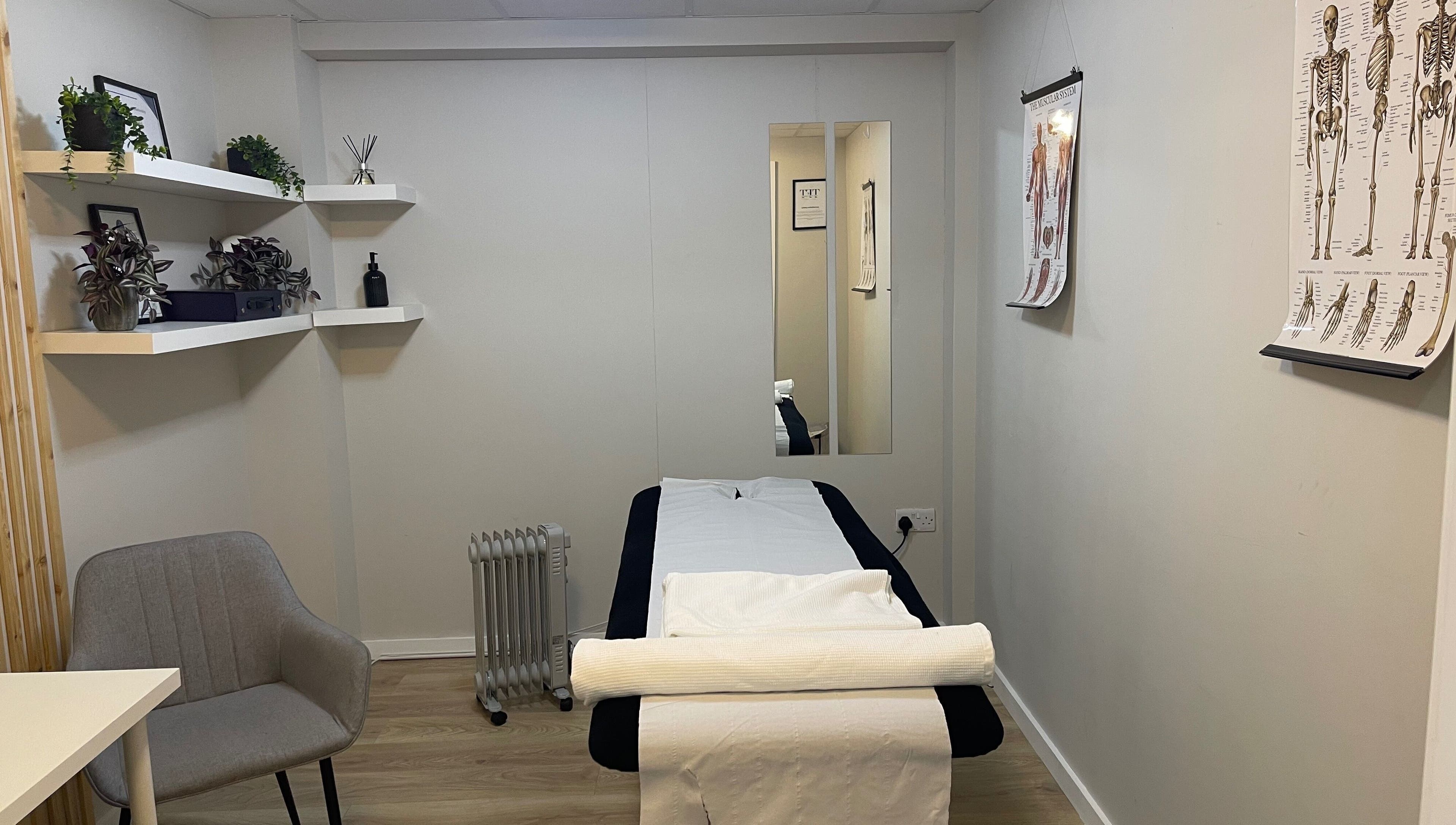 Calming therapy room at True Form Therapy Ltd, Three Legged Cross, England, GB with massage bed and decor.