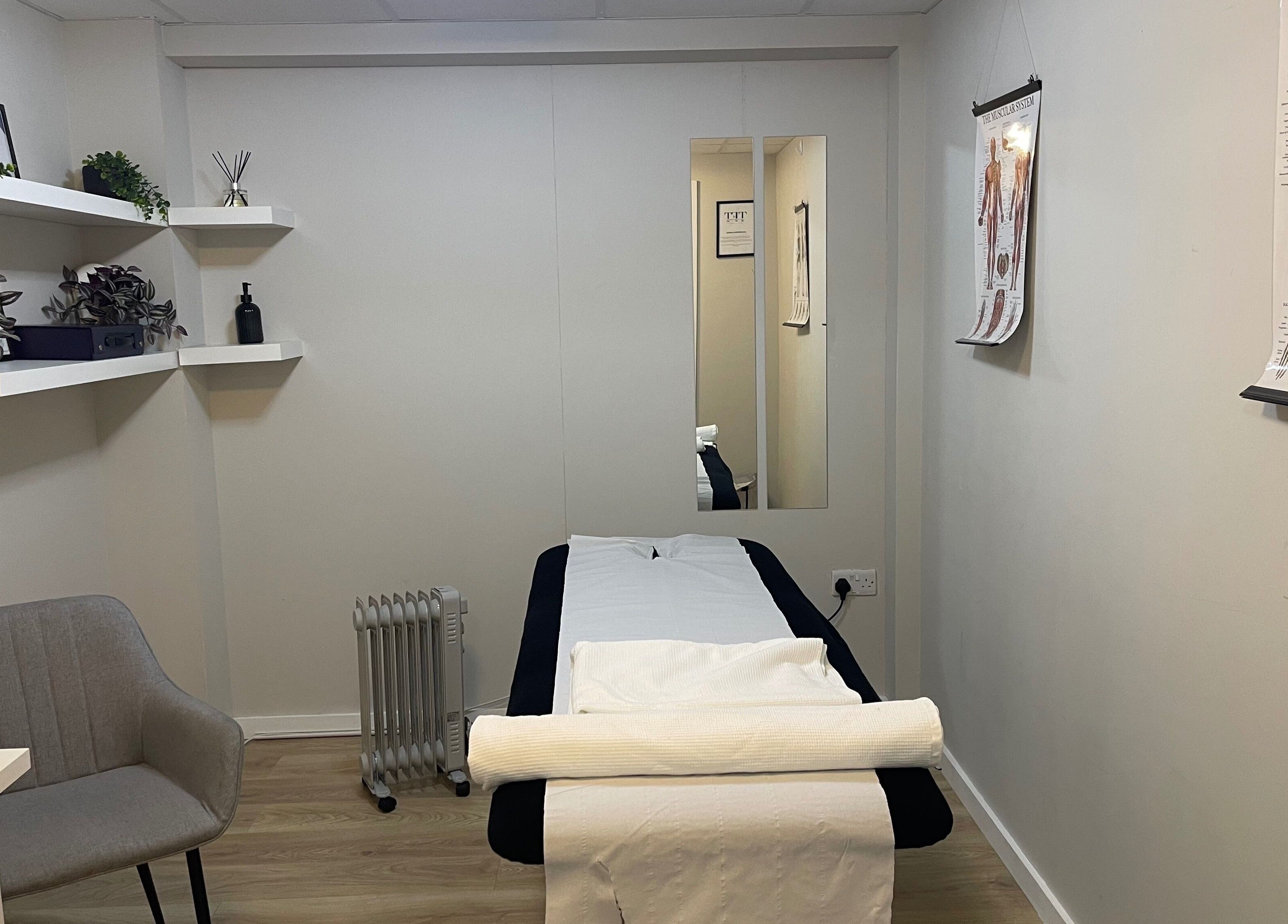 Calming therapy room at True Form Therapy Ltd, Three Legged Cross, England, GB with massage bed and decor.