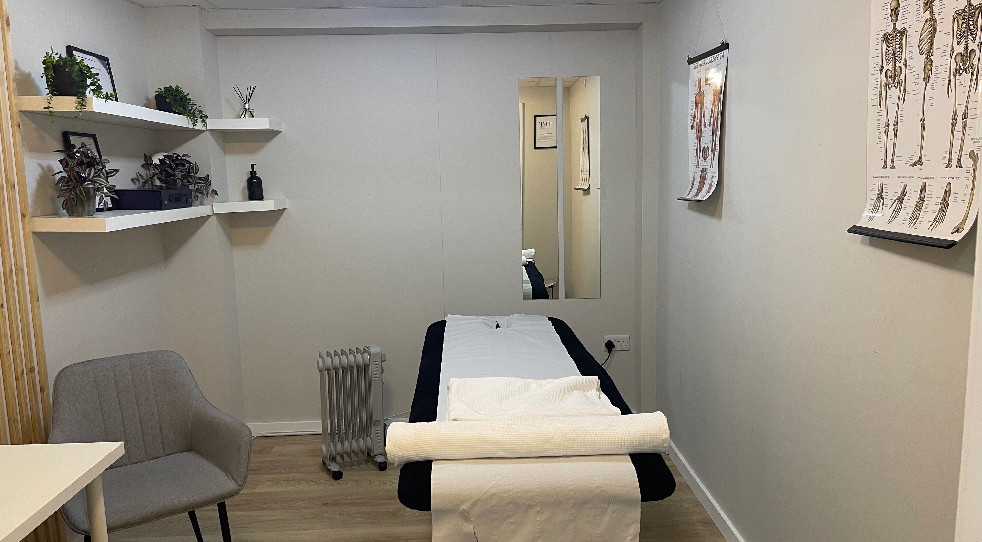 Calming therapy room at True Form Therapy Ltd, Three Legged Cross, England, GB with massage bed and decor.