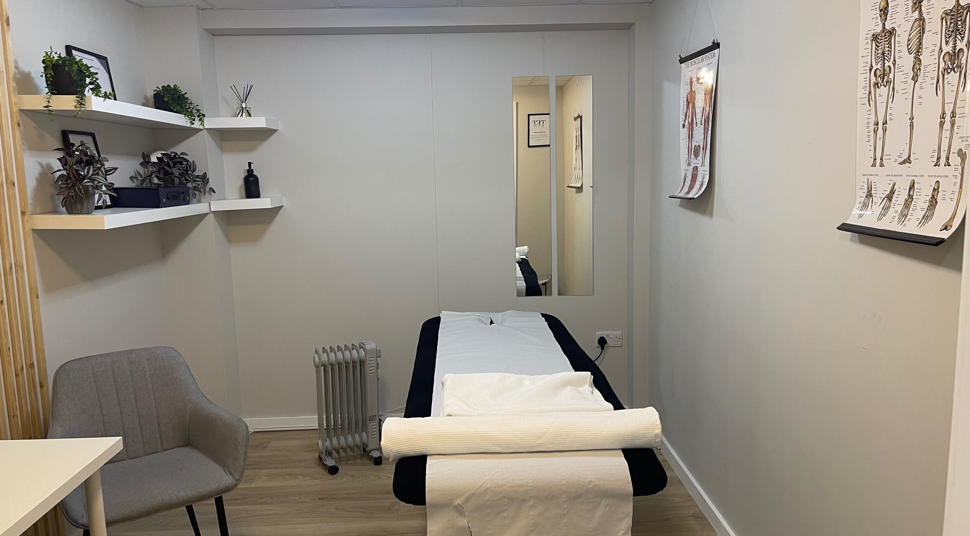 Calming therapy room at True Form Therapy Ltd, Three Legged Cross, England, GB with massage bed and decor.