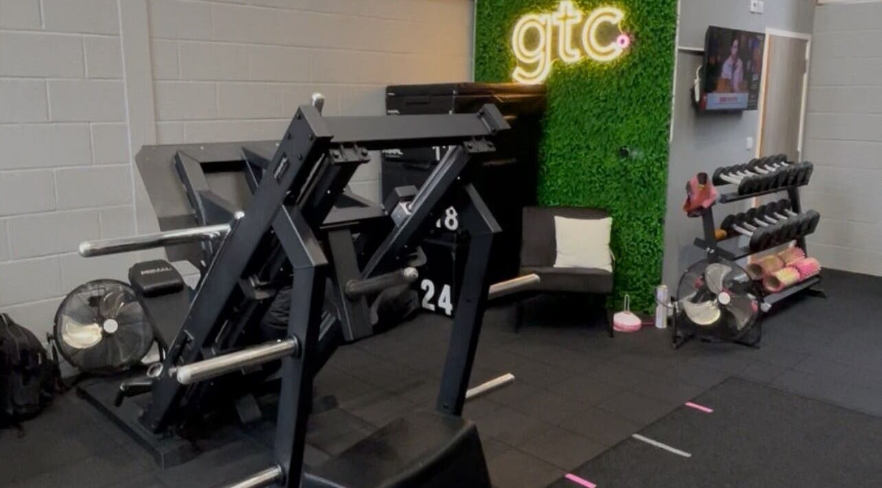 Modern fitness area at True Form Therapy Ltd, Three Legged Cross, England, GB featuring gym equipment and seating.