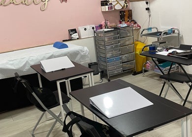 Training room at IA Brows and Beauty, London, England, GB showcasing neatly arranged desks and tools.