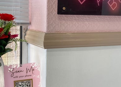 Flowers and sign at IA Brows and Beauty, London, England, GB. Bright and inviting decor with a QR code display.