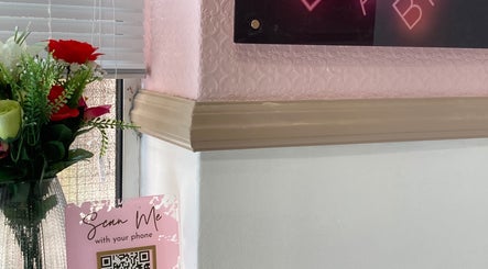 Flowers and sign at IA Brows and Beauty, London, England, GB. Bright and inviting decor with a QR code display.