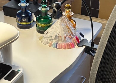 Nail polish palette on desk at Nails@32, Laleston, Wales, GB, showcasing vibrant color options.