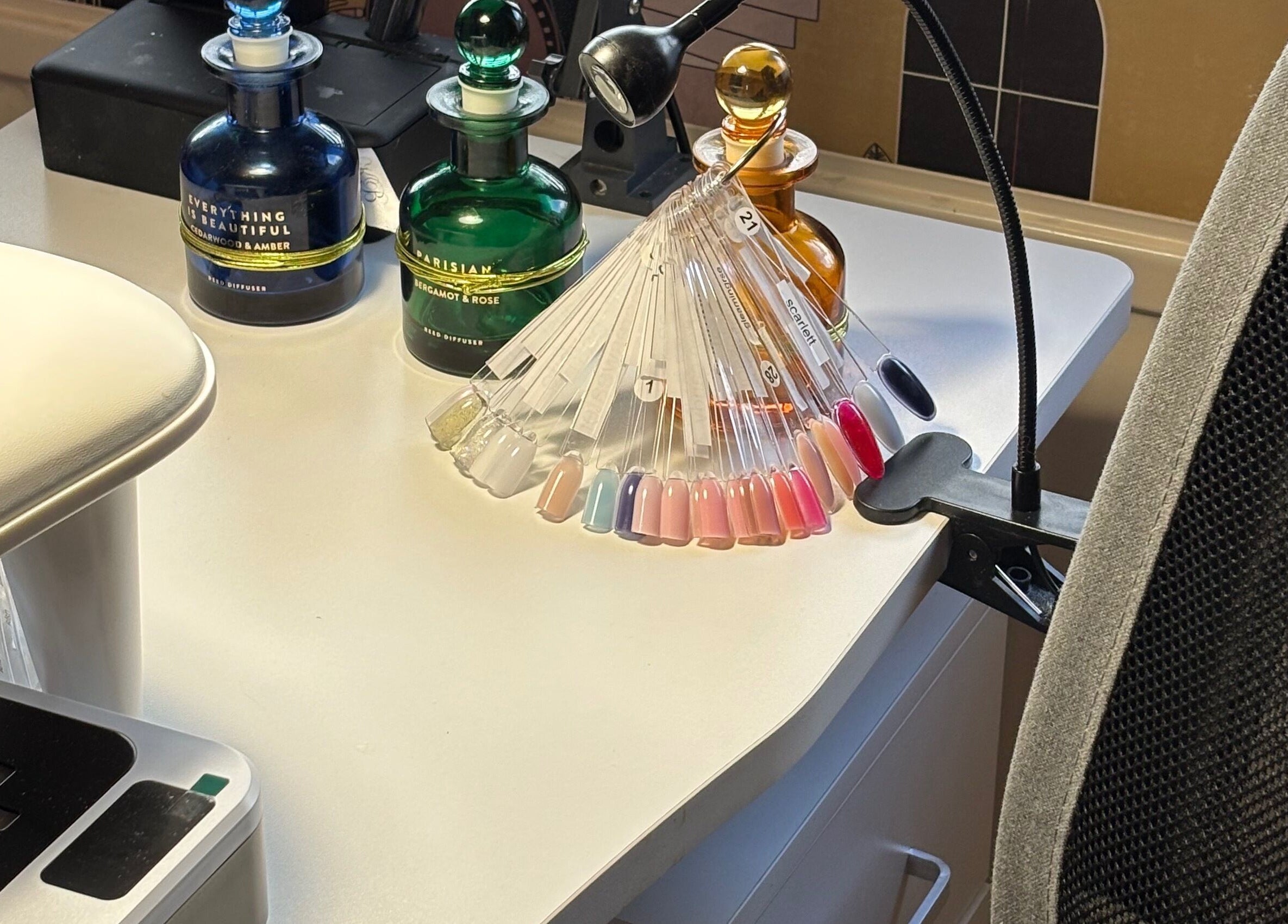 Nail polish palette on desk at Nails@32, Laleston, Wales, GB, showcasing vibrant color options.