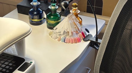 Nail polish palette on desk at Nails@32, Laleston, Wales, GB, showcasing vibrant color options.