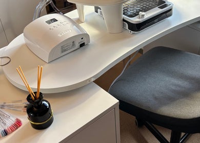 Chic manicure station at Nails@32, Laleston, Wales, GB, featuring a modern nail dryer and polish samples.