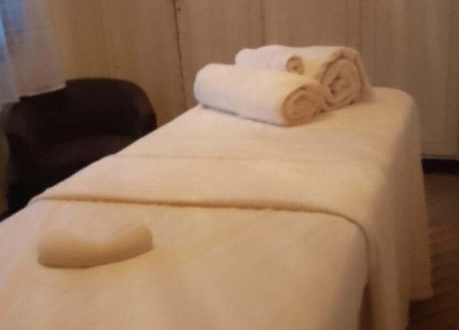 Habitación de masaje en Sigmasaludcapilar, Montevideo, Departamento De Montevideo, UY, con toallas blancas y luz suave.