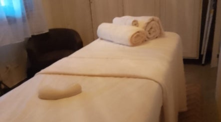 Habitación de masaje en Sigmasaludcapilar, Montevideo, Departamento De Montevideo, UY, con toallas blancas y luz suave.