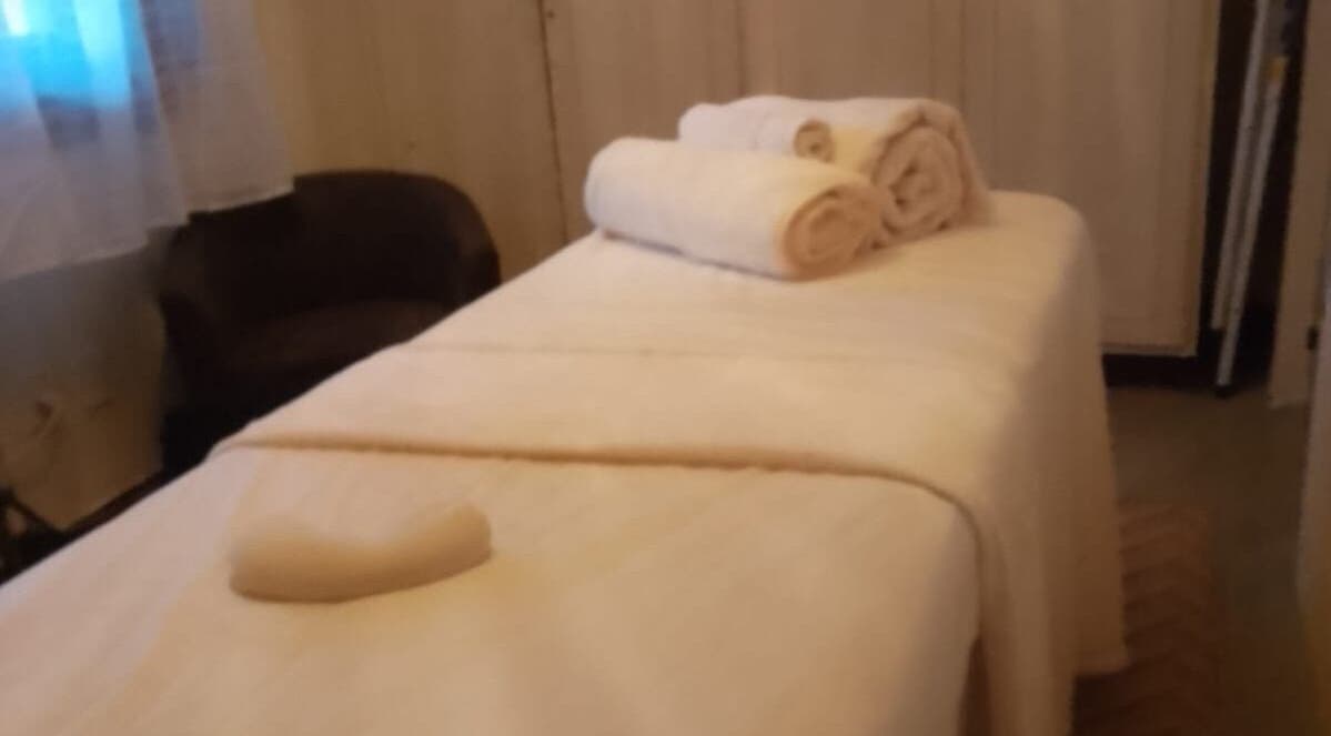 Habitación de masaje en Sigmasaludcapilar, Montevideo, Departamento De Montevideo, UY, con toallas blancas y luz suave.