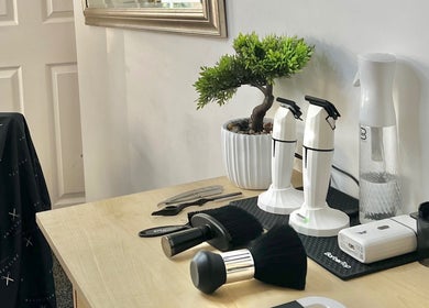 Barber tools and decor at Priestycuts, Barnstaple, England, GB, showcasing a stylish workstation.