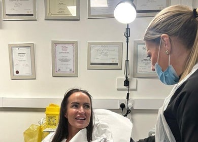 Patient consultation at Hydro Clinic, Liverpool, England with certificates displayed.