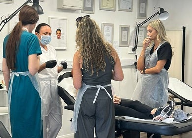 Team consultation at Hydro Clinic, Liverpool, England, GB. Staff discussing treatments over patient on a clinic bed.