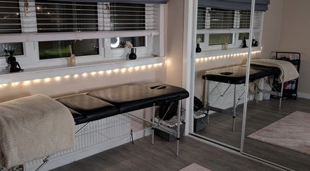 A tranquil treatment room at shbeautyfife in Cowdenbeath, Scotland, GB, featuring a massage bed and warm lighting.