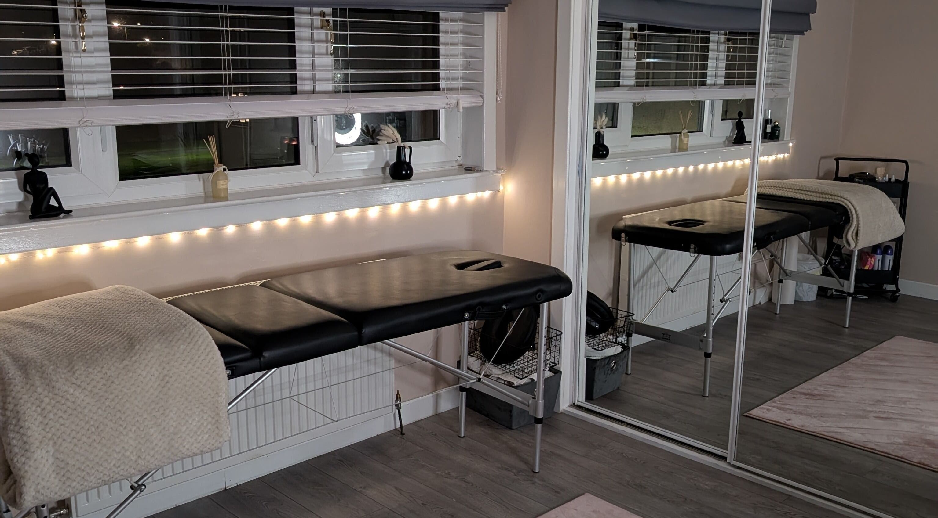 A tranquil massage room at Shbeautyfife, Cowdenbeath, Scotland, GB, with a comfortable black therapy bed.