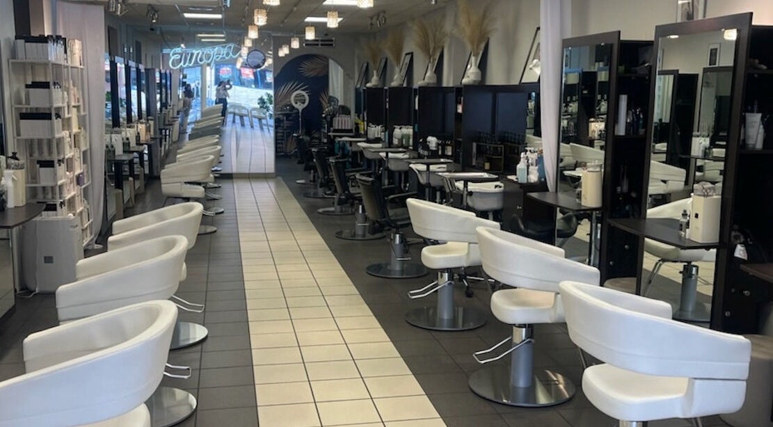 Interior of Europa Unisex Hair Design in Ridgewood, NY, US, showcasing modern styling chairs and mirrors.
