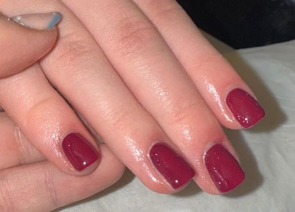 Stylish red nails with glossy finish at The Glow Lab, Corringham, England, GB.