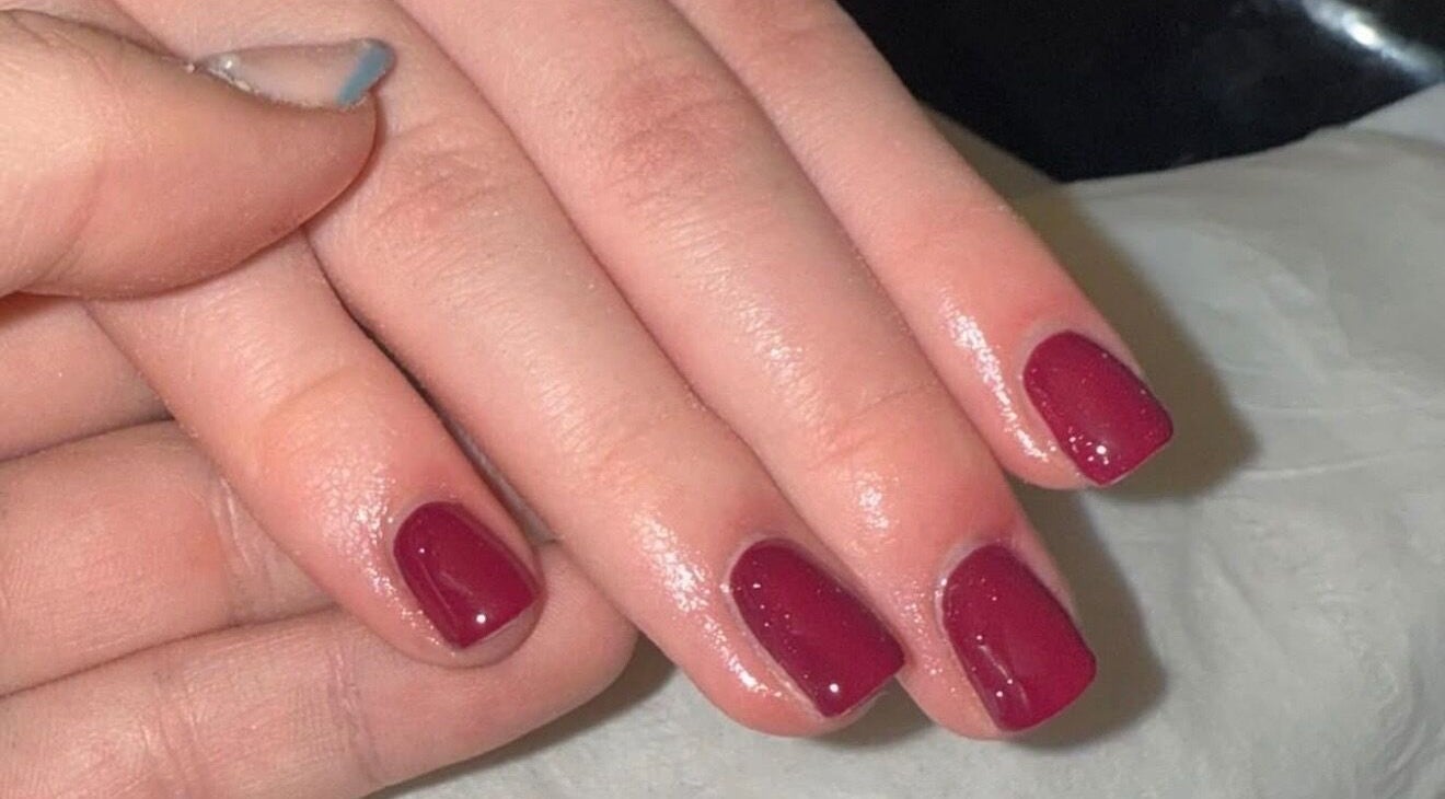 Stylish red nails with glossy finish at The Glow Lab, Corringham, England, GB.