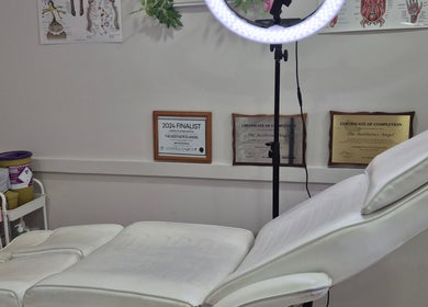 Professional beauty treatment room in Ipswich, England, GB with certifications displayed on the wall.