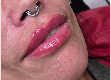 Closeup of glossy lips with nose ring at a beauty venue in Ipswich, England, GB.
