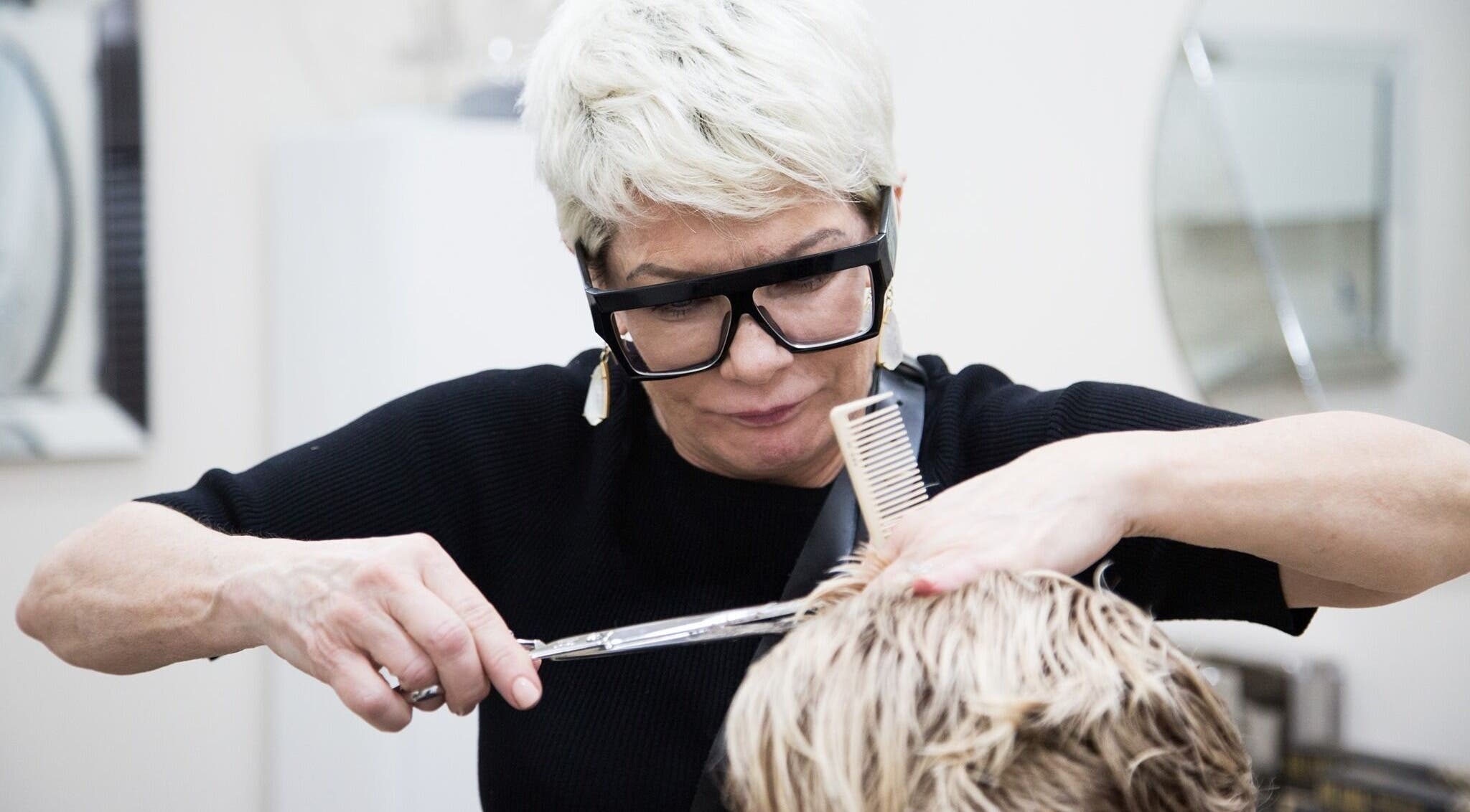 Expert stylist at Hair By Arensman in Plano, Texas, US, performing a precise haircut.