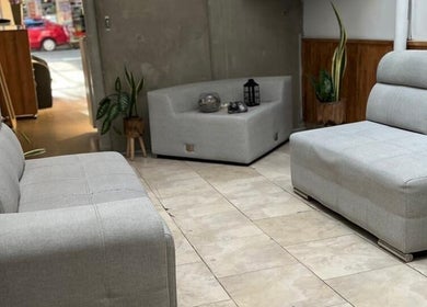 Elegante sala de espera en D'LART SALON, Medellín, Antioquia, CO, con sofás grises modernos.