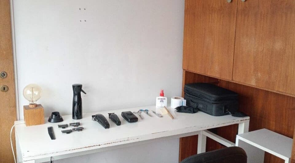 Mesa de trabajo en Julián Studio, Crg, Santa Fe, AR, con herramientas de peluquería y una lámpara.