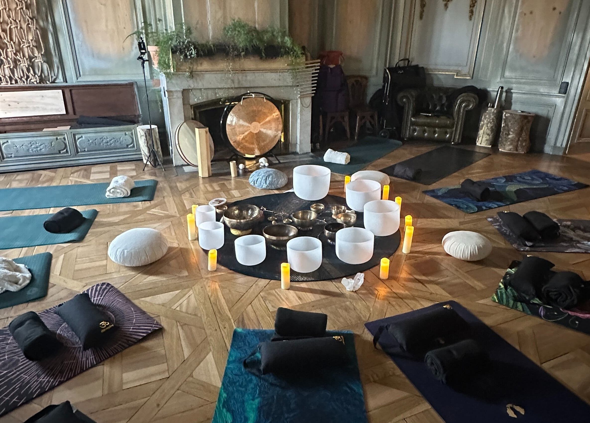Salle de yoga paisible à Sonora Experiences, Lyon, Auvergne-Rhône-Alpes, FR, avec tapis et bols chantants.