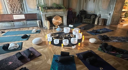 Salle de yoga paisible à Sonora Experiences, Lyon, Auvergne-Rhône-Alpes, FR, avec tapis et bols chantants.
