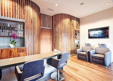 Modern salon interior at URBA SOLU LTD, London, England, GB, featuring wood panels and plush seating.