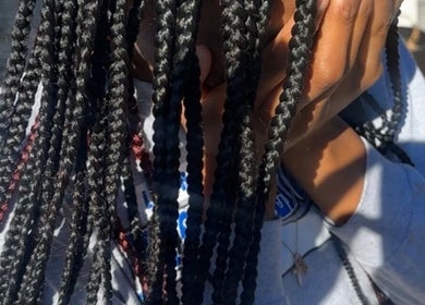 Close-up of intricate braids at Crownculturebraids_ in Killeen, Texas, US under natural sunlight.