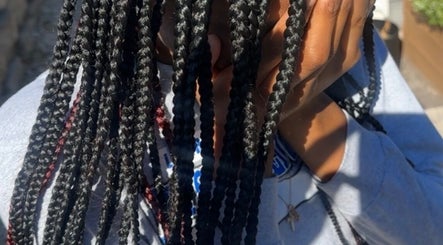 Close-up of intricate braids at Crownculturebraids_ in Killeen, Texas, US under natural sunlight.