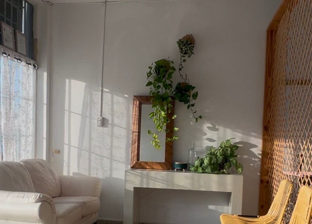 Espacio acogedor en Serene Nails, Bayamón, PR, con sillón blanco y plantas colgantes.