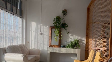 Espacio acogedor en Serene Nails, Bayamón, PR, con sillón blanco y plantas colgantes.