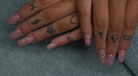 Stylish pink acrylic nails with tattoos at Bhadnpolishedd, Crestmead, Queensland, AU.
