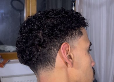 Man with curly fade hairstyle at 48 barber, Iași, Județul Iași, RO, showcasing expert styling.