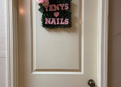 Entrada decorada de Yenys Nails en Panama City, US, con cartel verde y rosa.