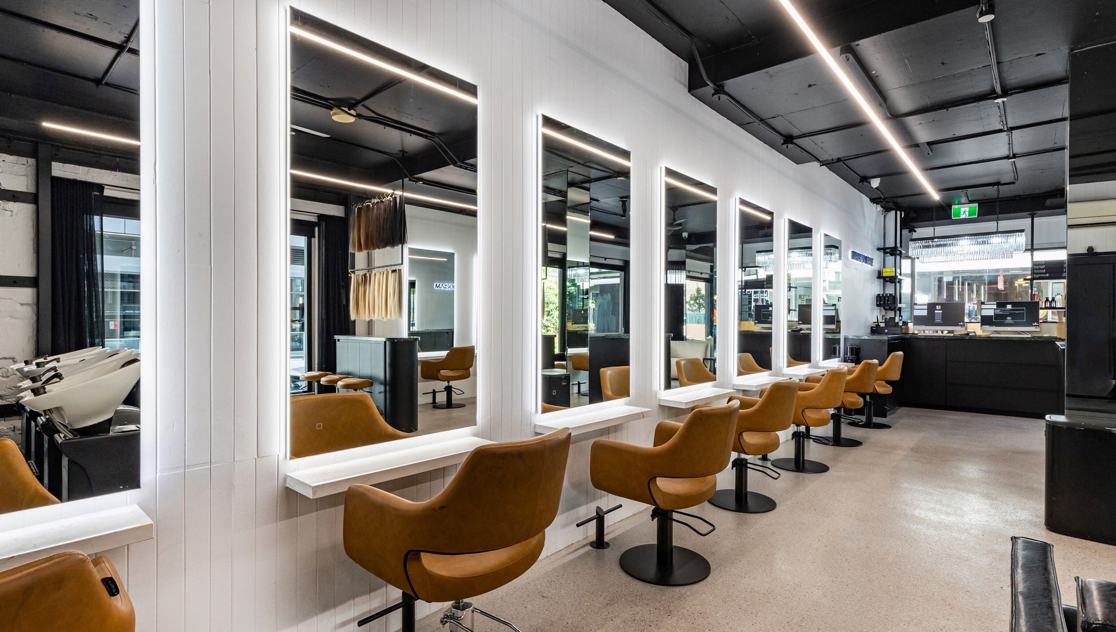 Interior view of MAISON MANE HAIR salon in Bondi Junction, New South Wales, AU showcasing modern seating and mirrors.